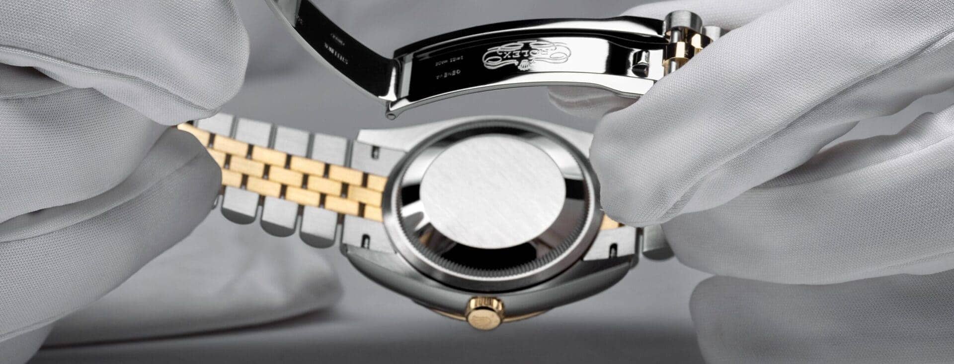 Gloved hands inspecting a Rolex case and bracelet during servicing. - Chang Ein Hong