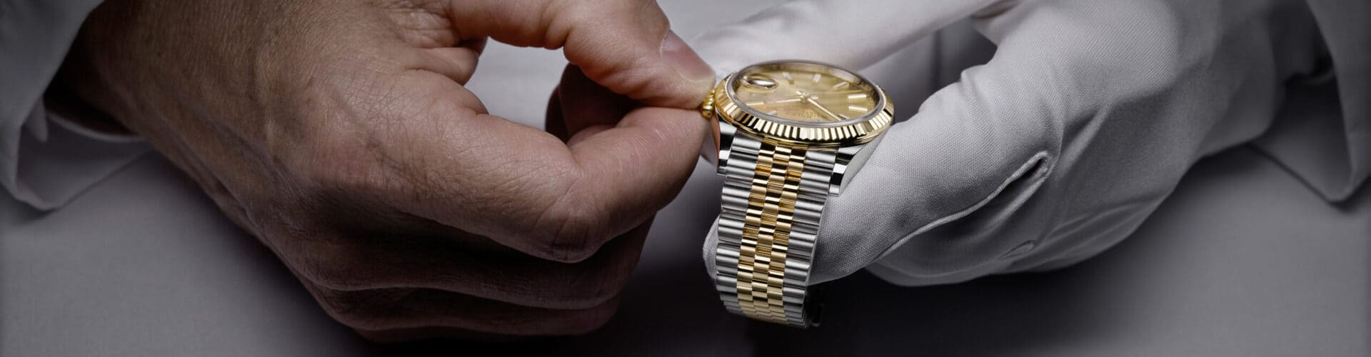 A watchmaker carefully adjusting a Rolex timepiece. - Chang Ein Hong