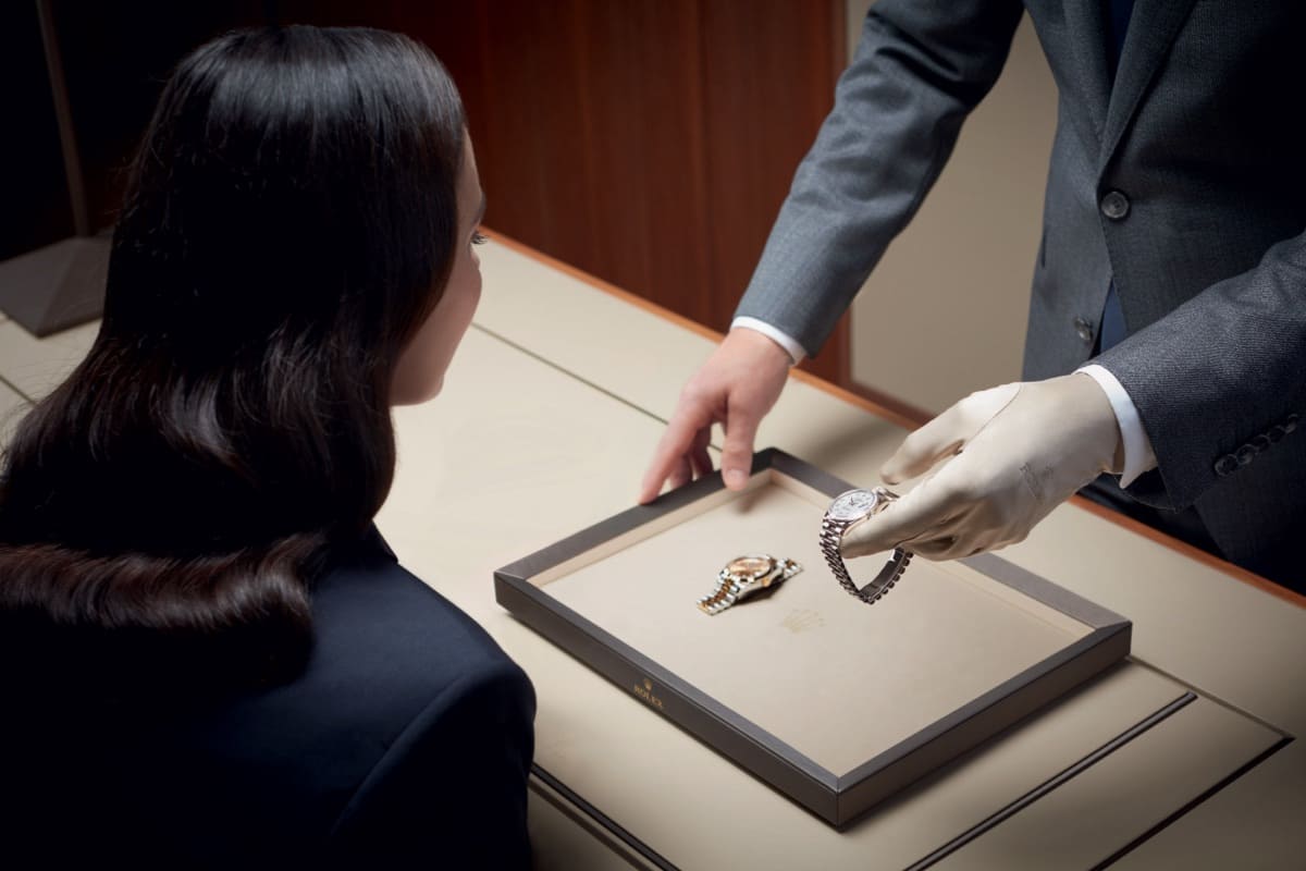 A Rolex specialist at presenting finely crafted timepieces on a tray to a client at a Rolex Retail Store - Chang Ein Hong