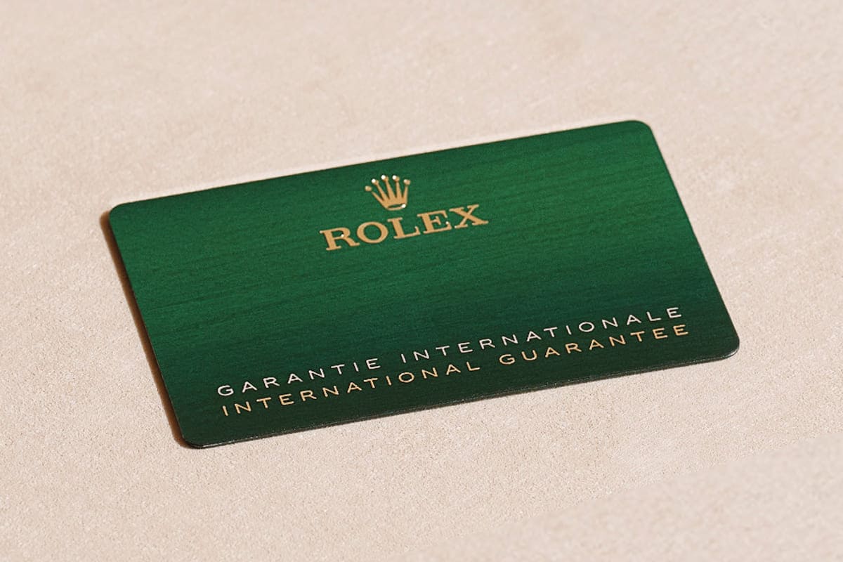 Image of the Rolex International Guarantee card in green leather holder. - Chang Ein Hong