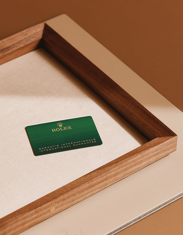 Rolex international guarantee card displayed on a wooden presentation tray - Chang Ein Hong
