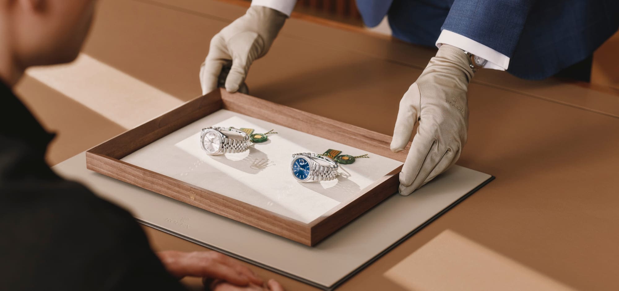 Rolex specialist presenting two watches to a client on a wooden tray - Chang Ein Hong
