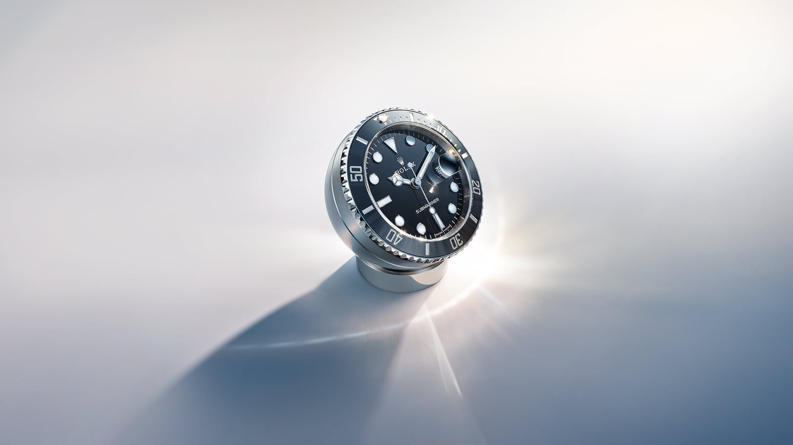 Rolex desk clock with secular calendar. Its hemispherical stainless steel case sits atop a ring-shaped base. - Chang Ein Hong