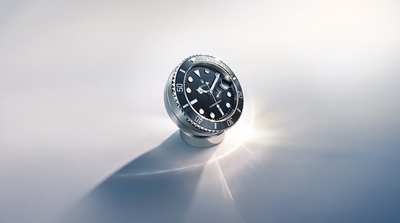 Rolex desk clock with secular calendar. Its hemispherical stainless steel case sits atop a ring-shaped base. - Chang Ein Hong